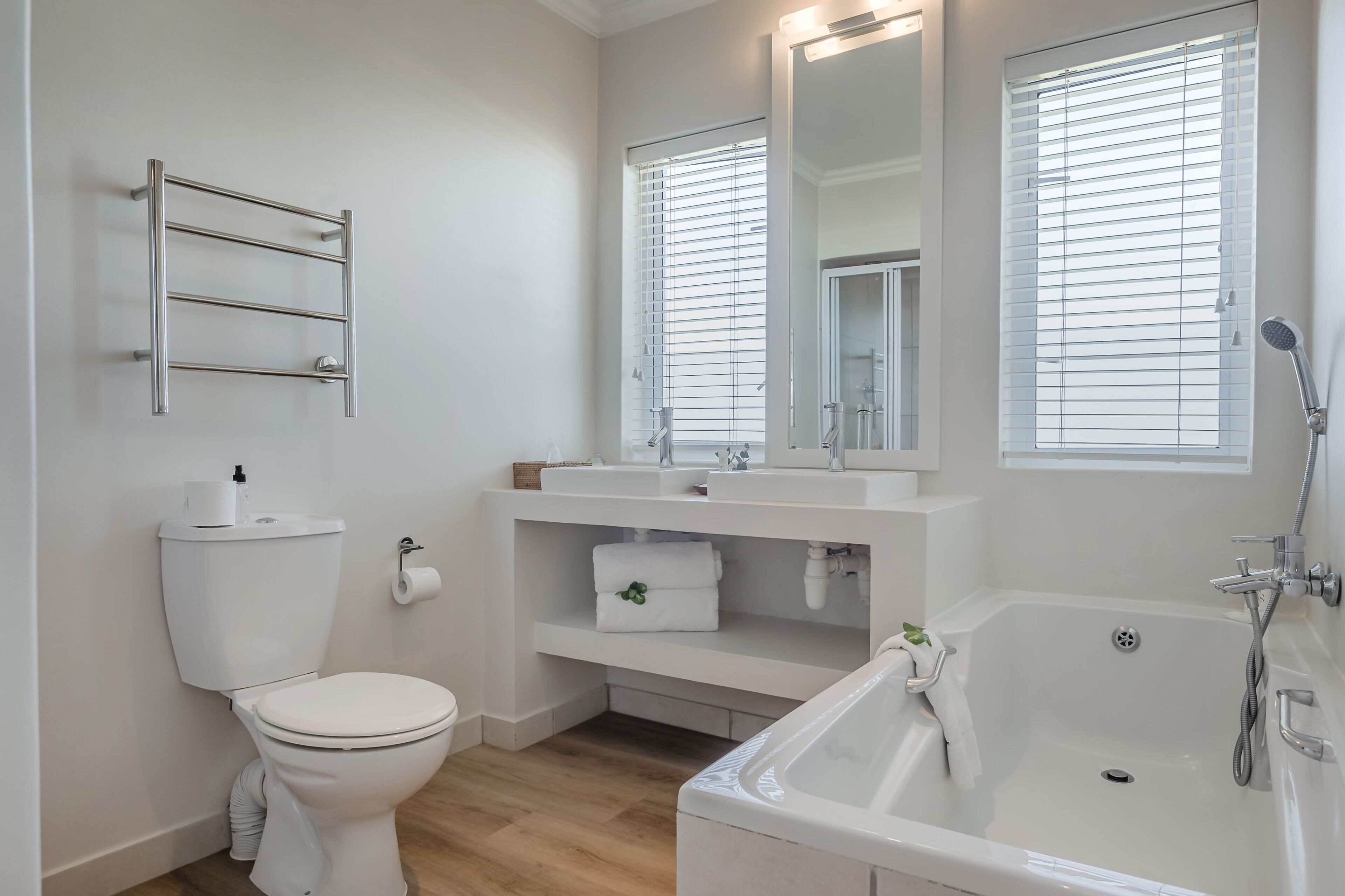 A modern bathroom with a toilet, sink, and bathtub.