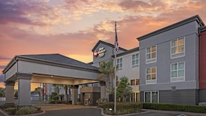 A Best Western Plus hotel with a covered entrance, flagpole, and a clear sky.