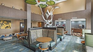 A hotel lobby with seating areas, a coffee station, and a decorative ceiling.
