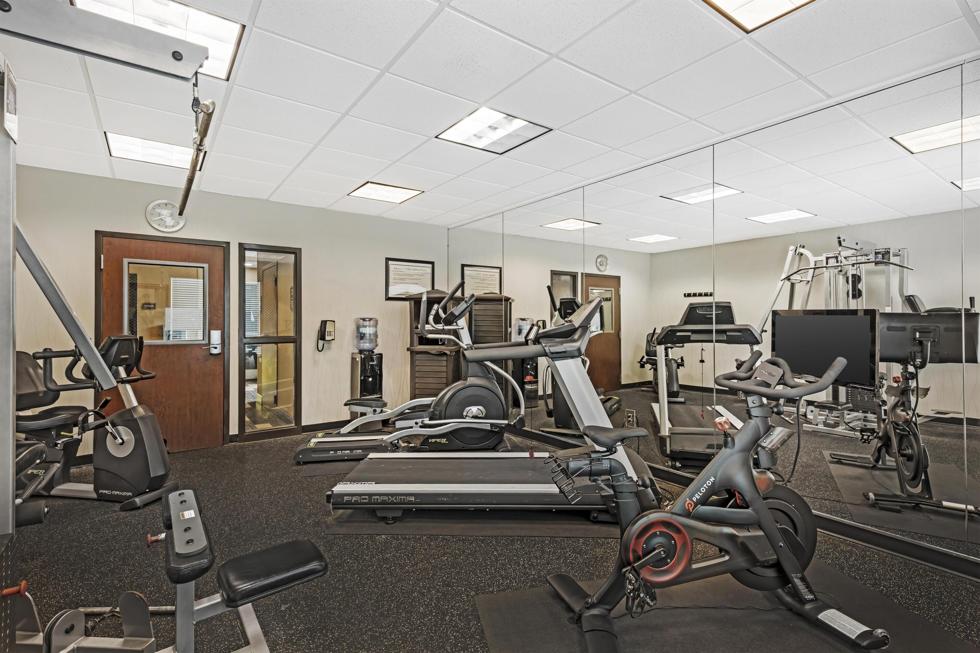 A gym with treadmills, elliptical machines, and weight equipment.