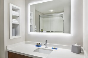 A modern bathroom with a white sink, a mirror, and a glass shower enclosure. - Holiday Inn Express Palatka Northwest by IHG (Palatka)