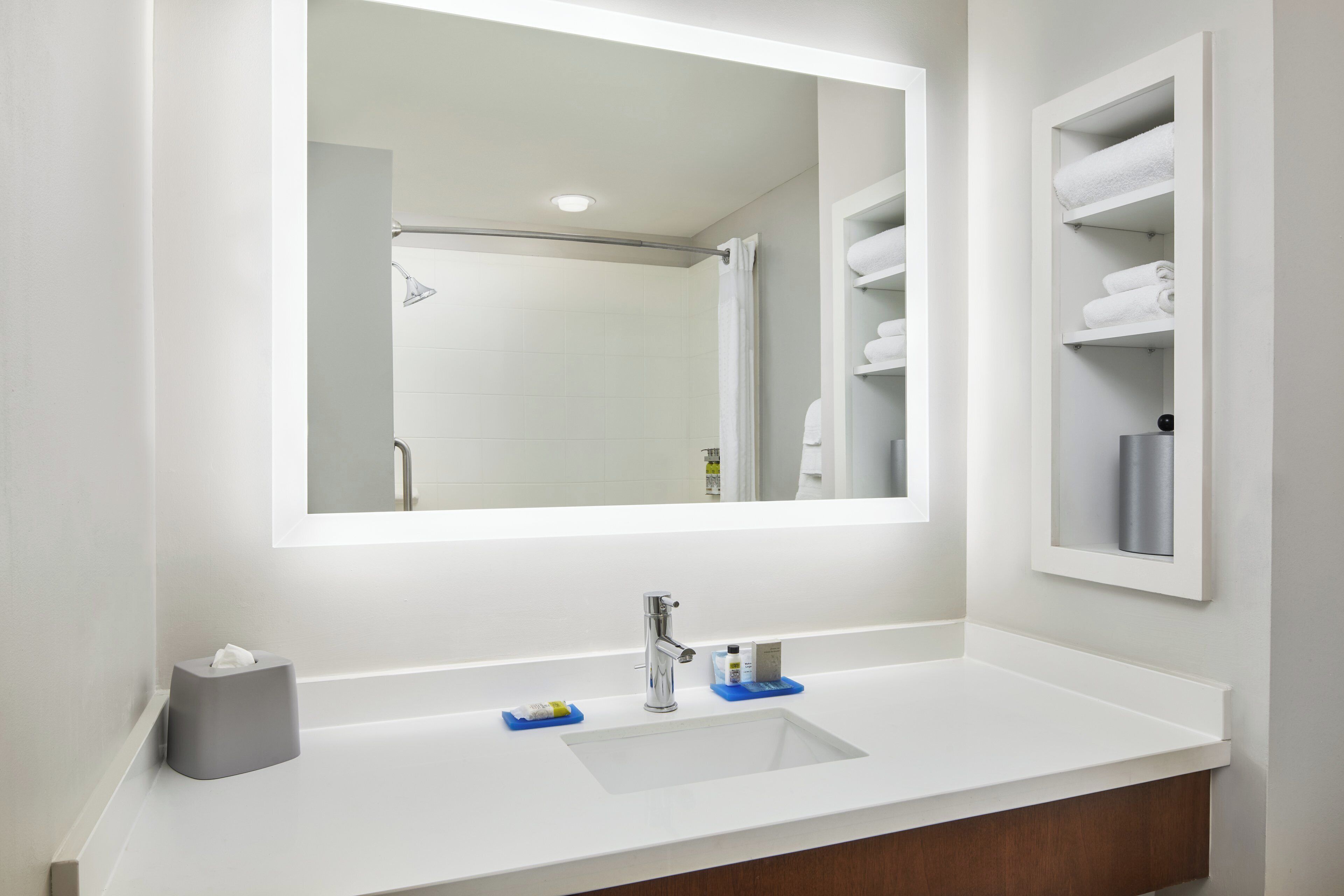 Une salle de bain avec un lavabo blanc, un miroir et un porte-serviettes.