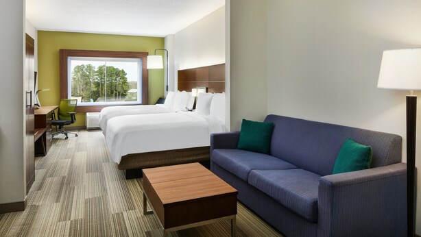 Ein Hotelzimmer mit einem Bett, einer Couch, einem Schreibtisch und einem Sessel.