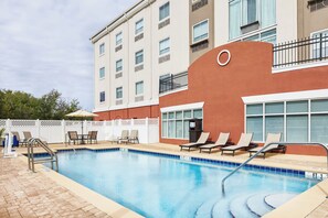 A hotel pool area with lounge chairs and a pool ladder. - Holiday Inn Express Palatka Northwest by IHG (Palatka)