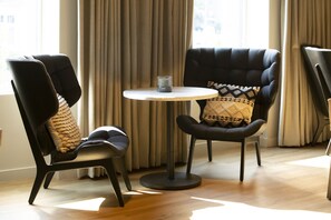 Relax in a serene space with a large window, two armchairs, and a small table.