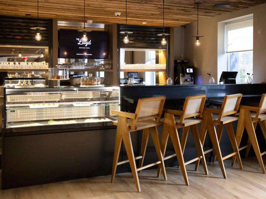 Eine Bar mit Theke, Hockern und einer Kühlvitrine.