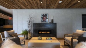 A modern living room with a fireplace, two sofas, a coffee table, and a large painting above the mantel. - The Lloyd Stamford, Tapestry Collection by Hilton (Stamford)
