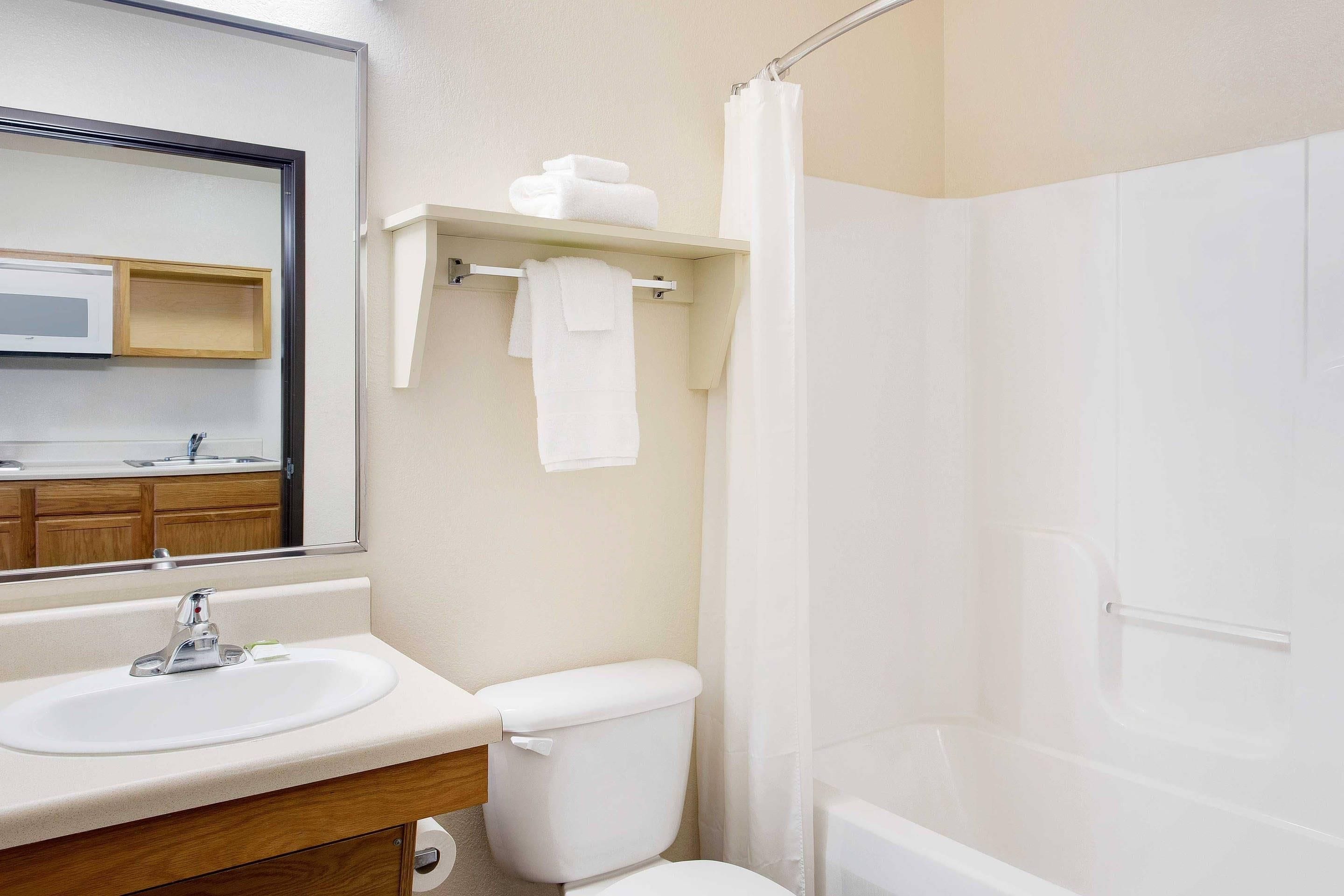 A bathroom with a sink, mirror, toilet, and shower.