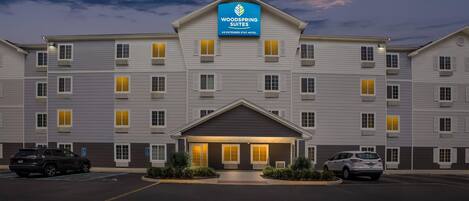 A multi-story hotel with a prominent sign for WoodSpring Suites.