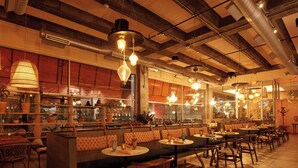 A restaurant interior with high ceilings, exposed beams, and a variety of seating options including booths and tables. - Hotel Indigo El Paso Downtown by IHG (El Paso)