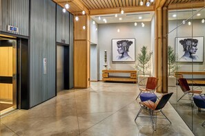 A modern interior with a reception desk, seating area, and artwork on the walls.