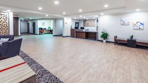 Un vestíbulo amplio con mostrador de recepción, zona de estar y un espacio abierto grande.