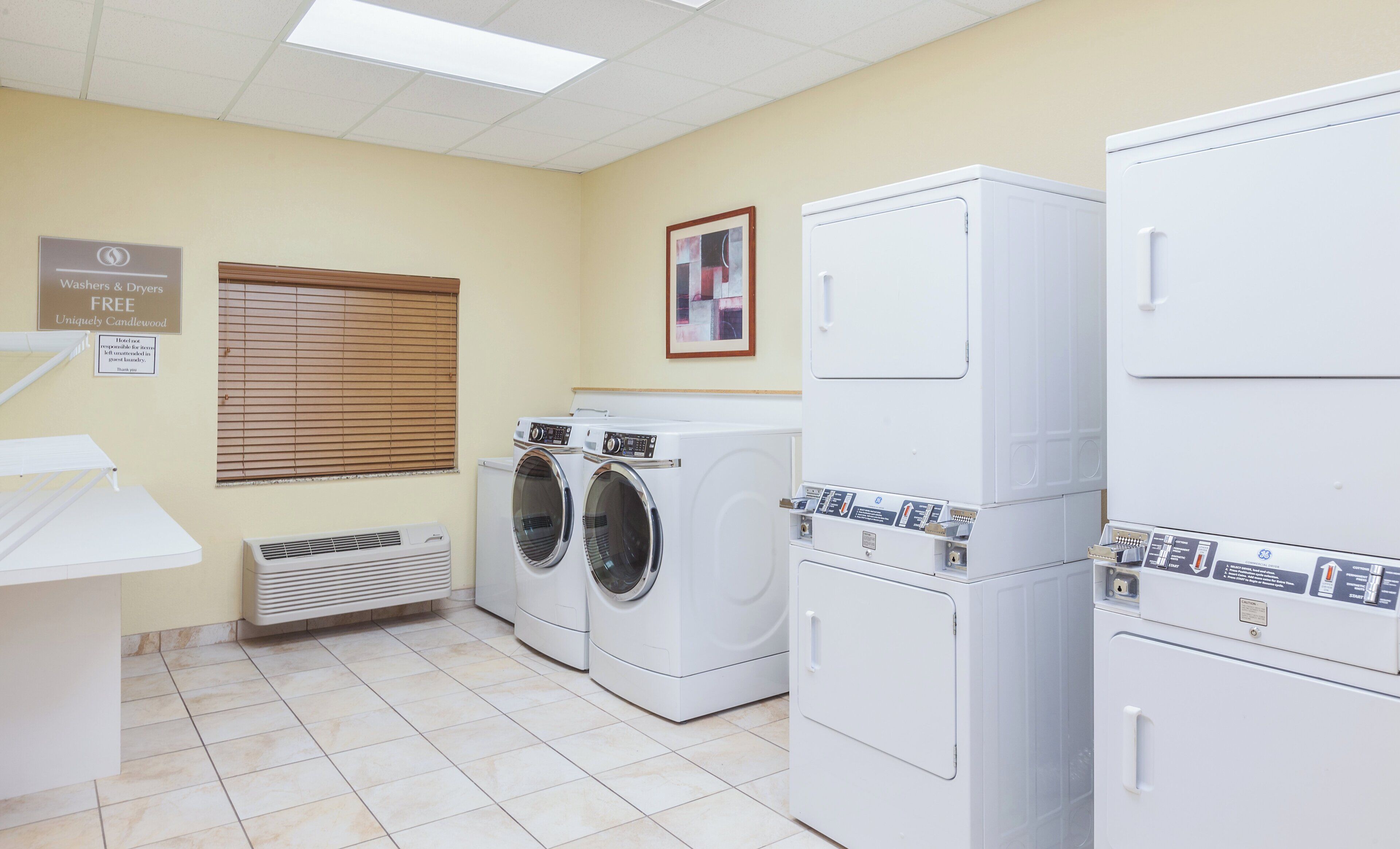 A laundry room with washers and dryers, a sign indicating free use, and a vent.