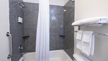 A modern bathroom with a shower, a bathtub, and a towel rack.