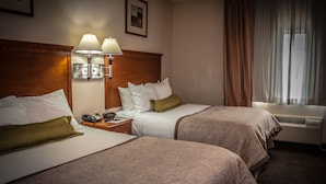A hotel room with two beds, a bedside table with a lamp, a phone, and a window with curtains. - Candlewood Suites New Iberia by IHG (New Iberia)