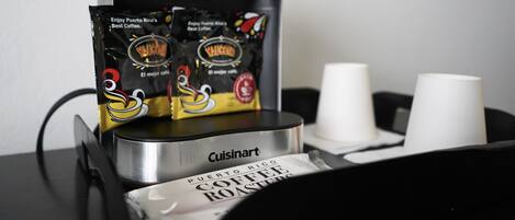 Una cafetera Cuisinart con un paquete de café de Puerto Rico y dos vasos blancos desechables.