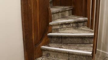 Un escalier en colimaçon avec des rampes en bois et des marches en pierre.