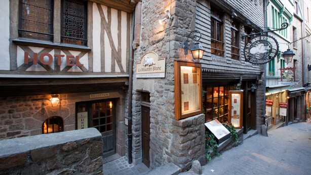 Un hotel con un cartel que dice 'HOTEL Le Mouton Blanc'.