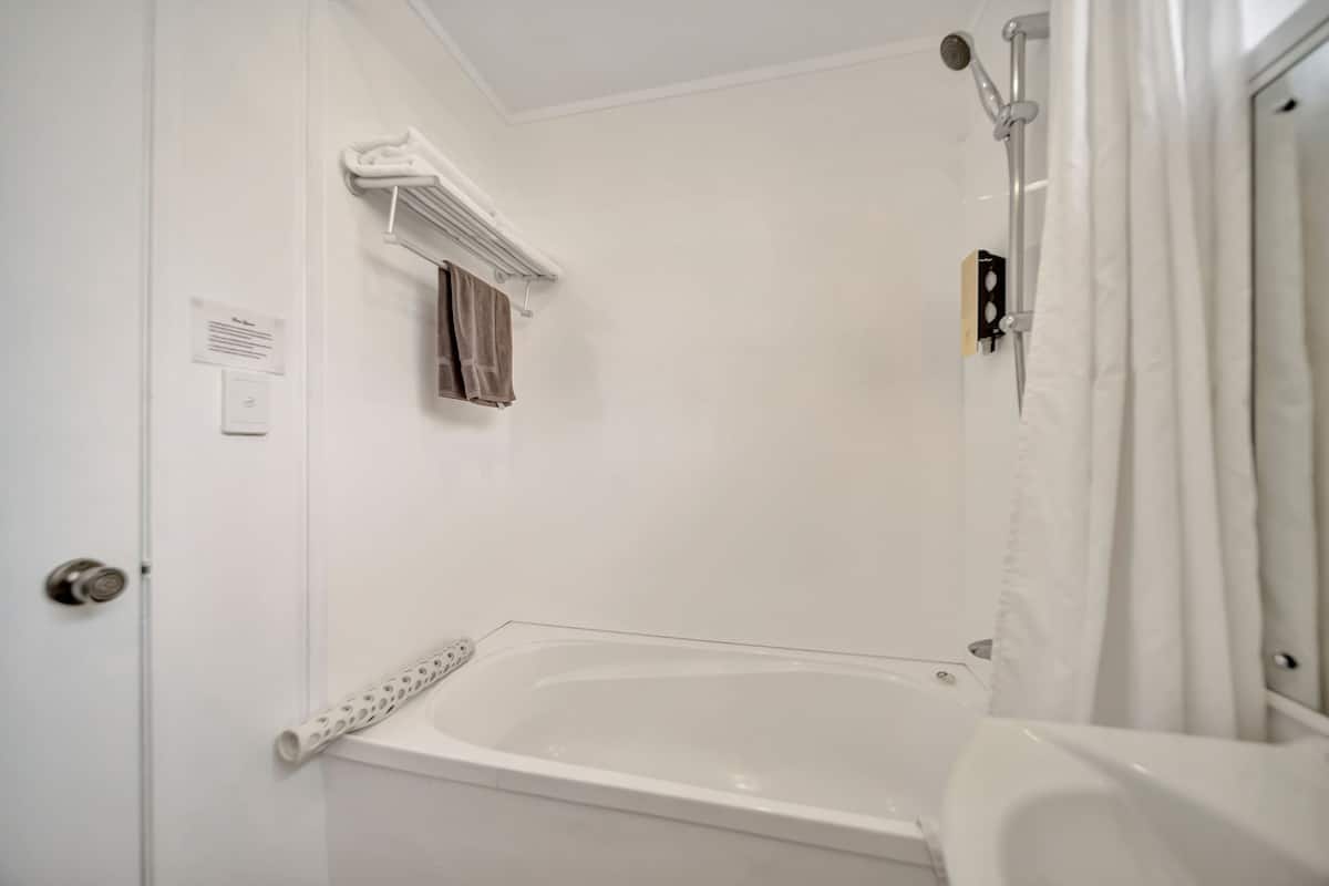 Un baño con bañera, ducha e inodoro.