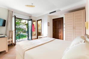 A hotel room with a bed, a desk, a chair, a wardrobe, and a sliding glass door leading to a balcony. - Relais Villa Angiolina (Sorrento)