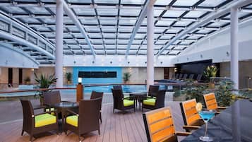 Una piscina techada, sillones reclinables de piscina