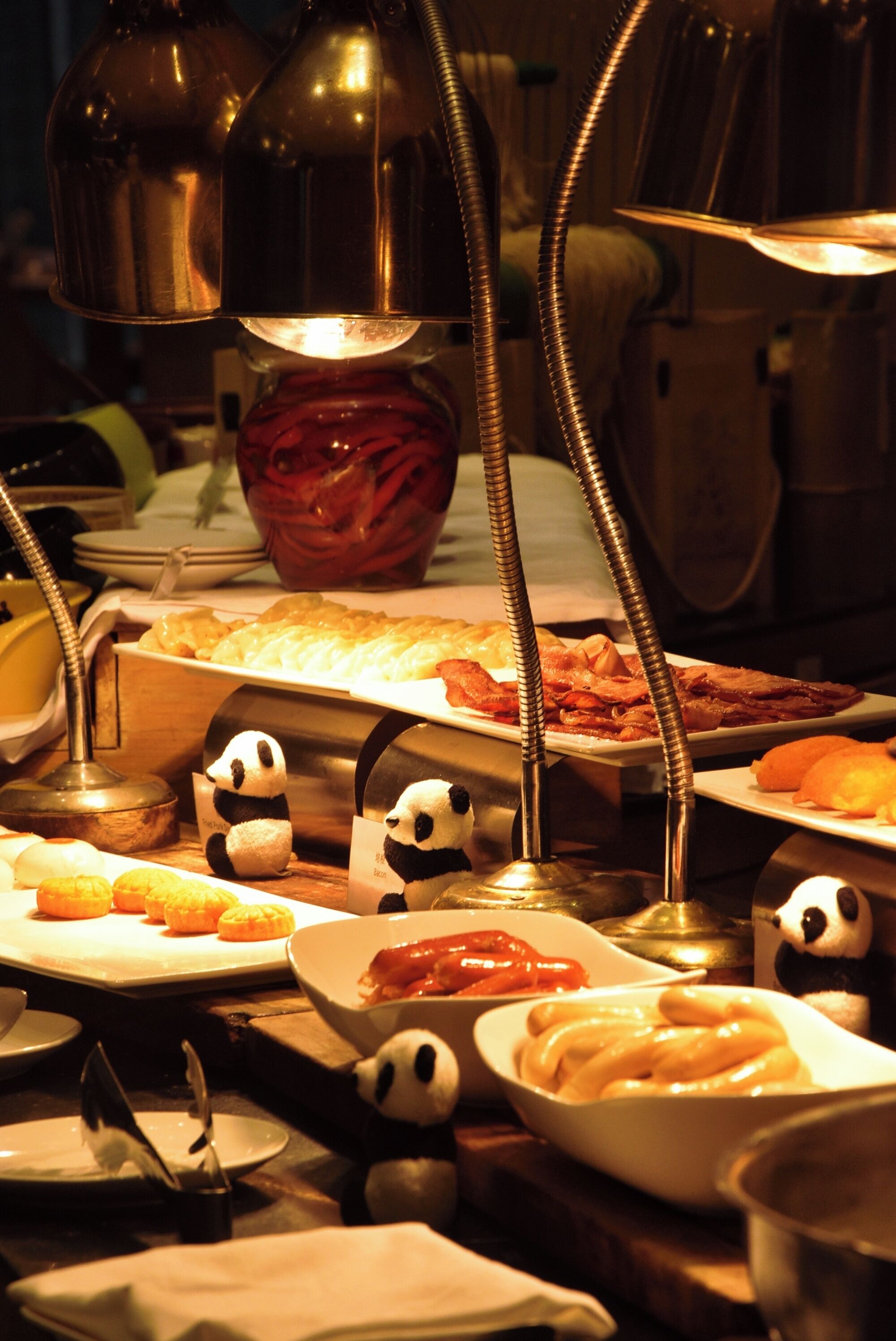 A buffet with various dishes and panda figurines.