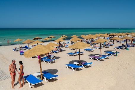 Playa privada, playa de arena blanca, camastros y sombrillas