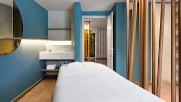 Relax in a stylish room with a neatly made bed, sink, and curved ceiling.