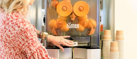 A person operating a coffee machine with a digital display, dispensing coffee into a cup.