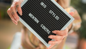 A person holding a sign with the text "IBIS STYLES MENTON CENTRE". - ibis Styles Menton Centre (Menton)