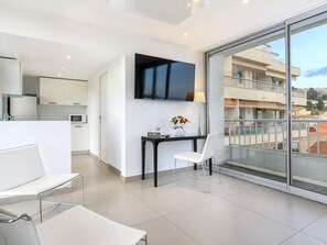 Un appartamento moderno con cucina, zona pranzo e un balcone vista città.