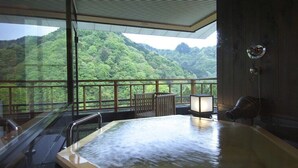 Un jacuzzi con vista a una montaña boscosa.