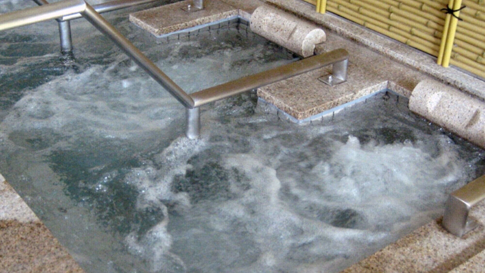 A hot tub with metal railings and stone steps.