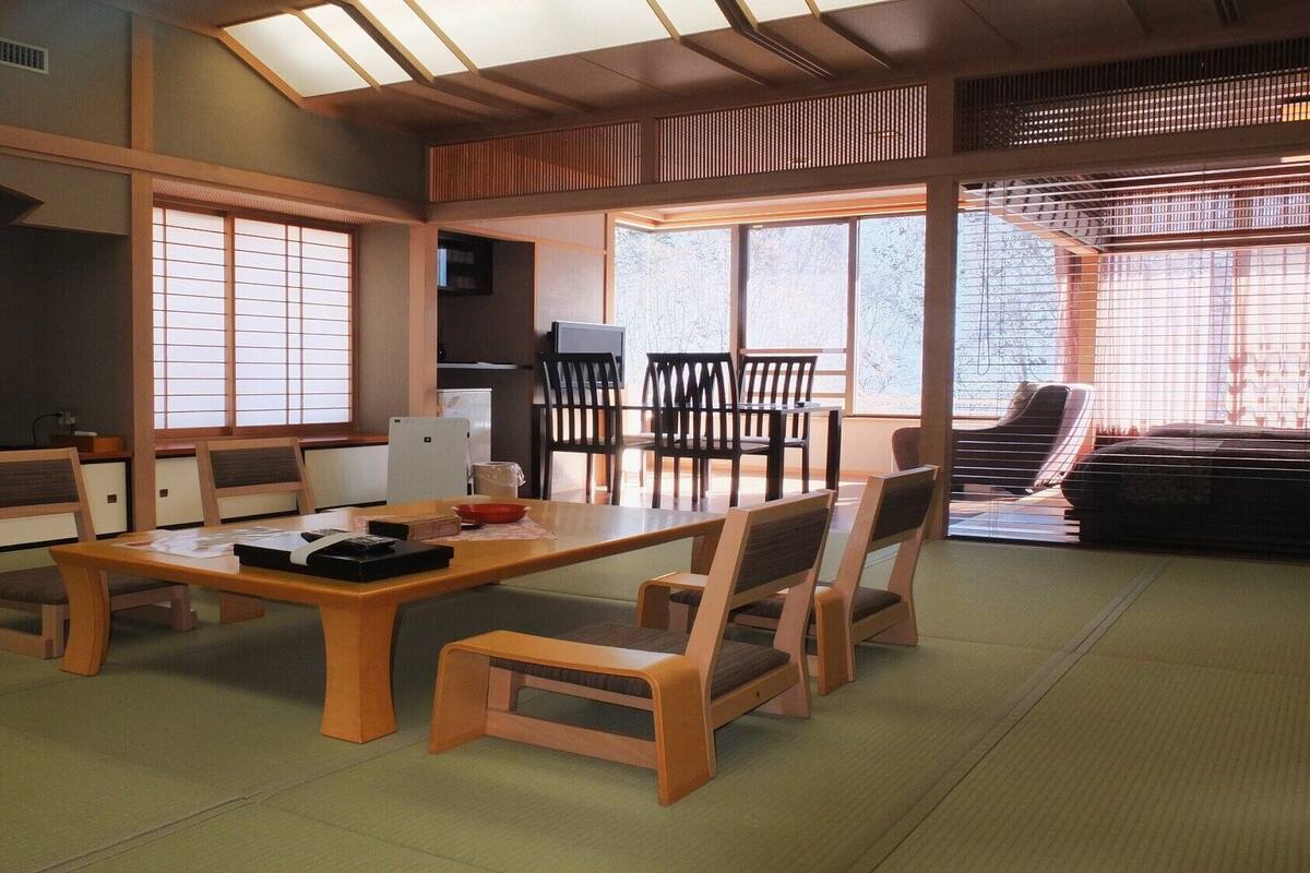 A traditional Japanese-style room with tatami flooring, a low wooden table, and sliding doors.