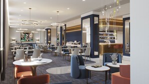 Um lobby moderno de hotel com várias áreas de refeições, um bar e um balcão de recepção.