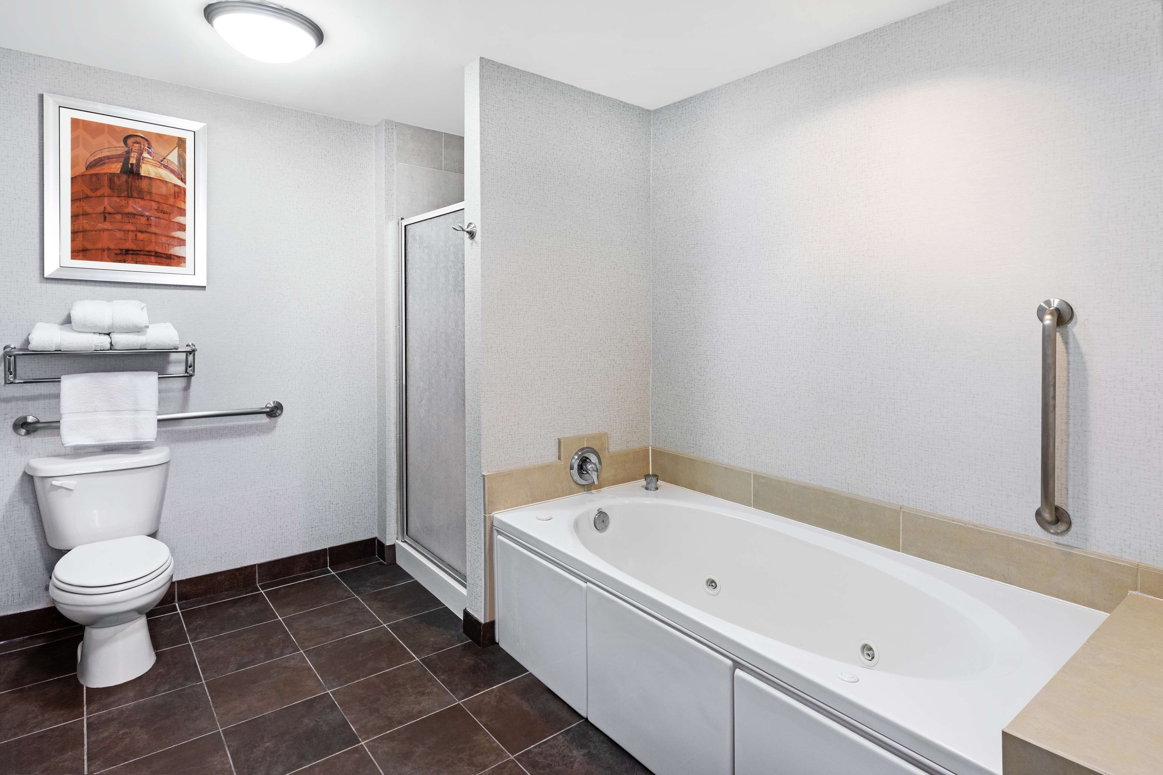 A modern bathroom with a toilet, shower, and bathtub.