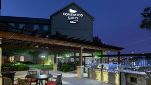 A patio area with outdoor seating, a grill station, and a sign for Homewood Suites by Hilton. - Homewood Suites by Hilton Waco (Waco)