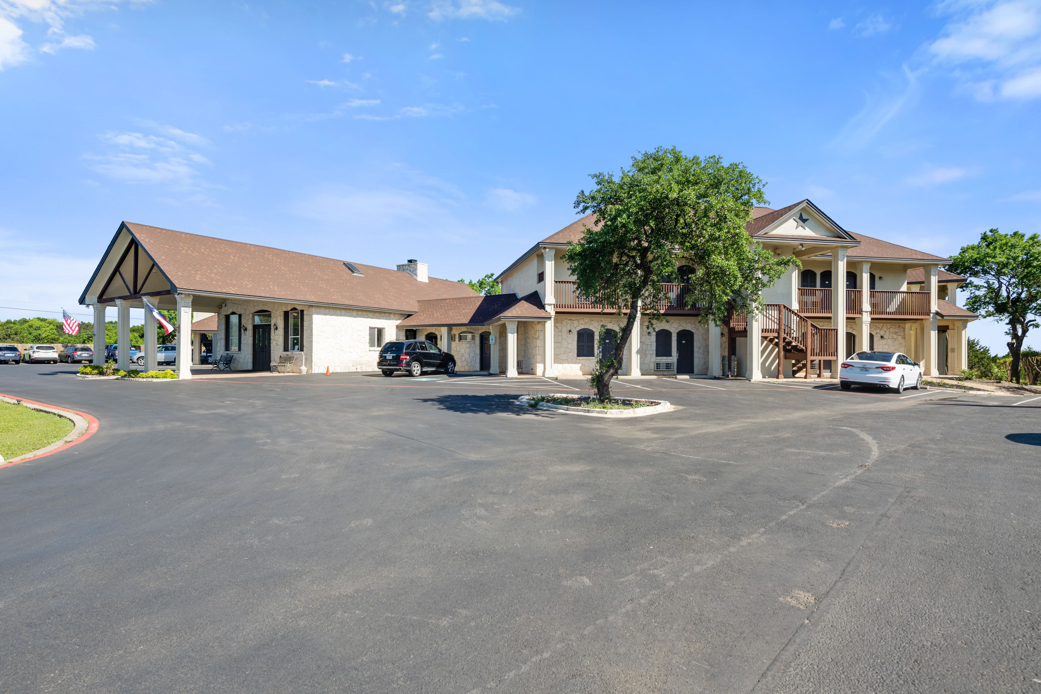 A two-story building with a parking lot in front.