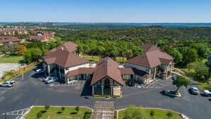 A multi-story building with a central courtyard and parking lot. - Mountain Star Lodge (Austin)