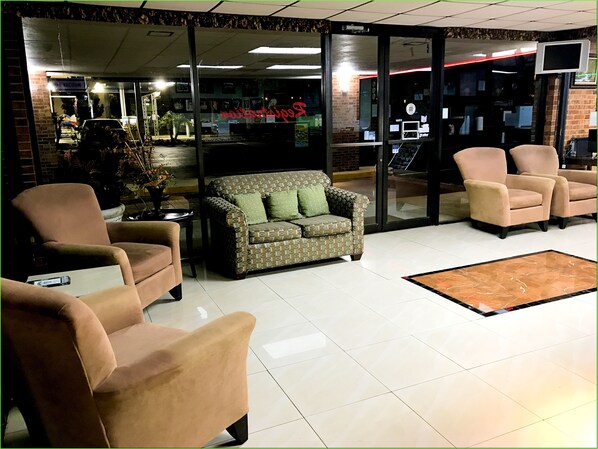 Relax in our inviting lobby lounge, featuring a comfortable seating area with armchairs and a sofa.