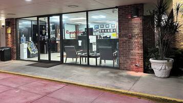 A registration area with glass doors, a reception desk, and a seating area with chairs and tables.