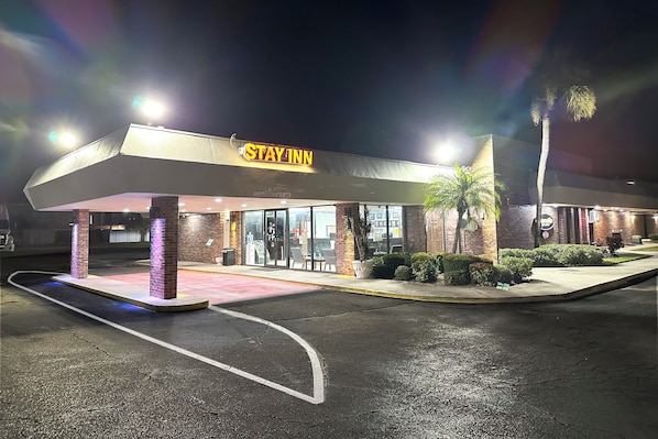 A Stay Inn hotel with a covered entrance, clear signage, and a parking lot.