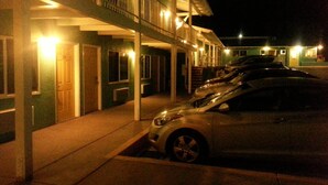 A hotel with a covered parking area and multiple cars parked. - Villa Motel (San Luis Obispo)