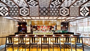 A restaurant with a central bar, multiple seating areas, and patterned ceiling designs. - Miyako Hybrid Hotel Torrance (Torrance)