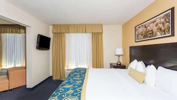A hotel room with a bed, a TV, a desk, and a chair.