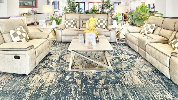 A spacious lobby with a high ceiling, a wooden staircase, and a large clock. There are multiple sofas and a coffee table in the center. - Wingate by Wyndham Houma LA (Houma)
