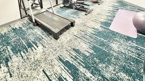 A fitness room with treadmills, elliptical machines, and a yoga mat. - Wingate by Wyndham Houma LA (Houma)