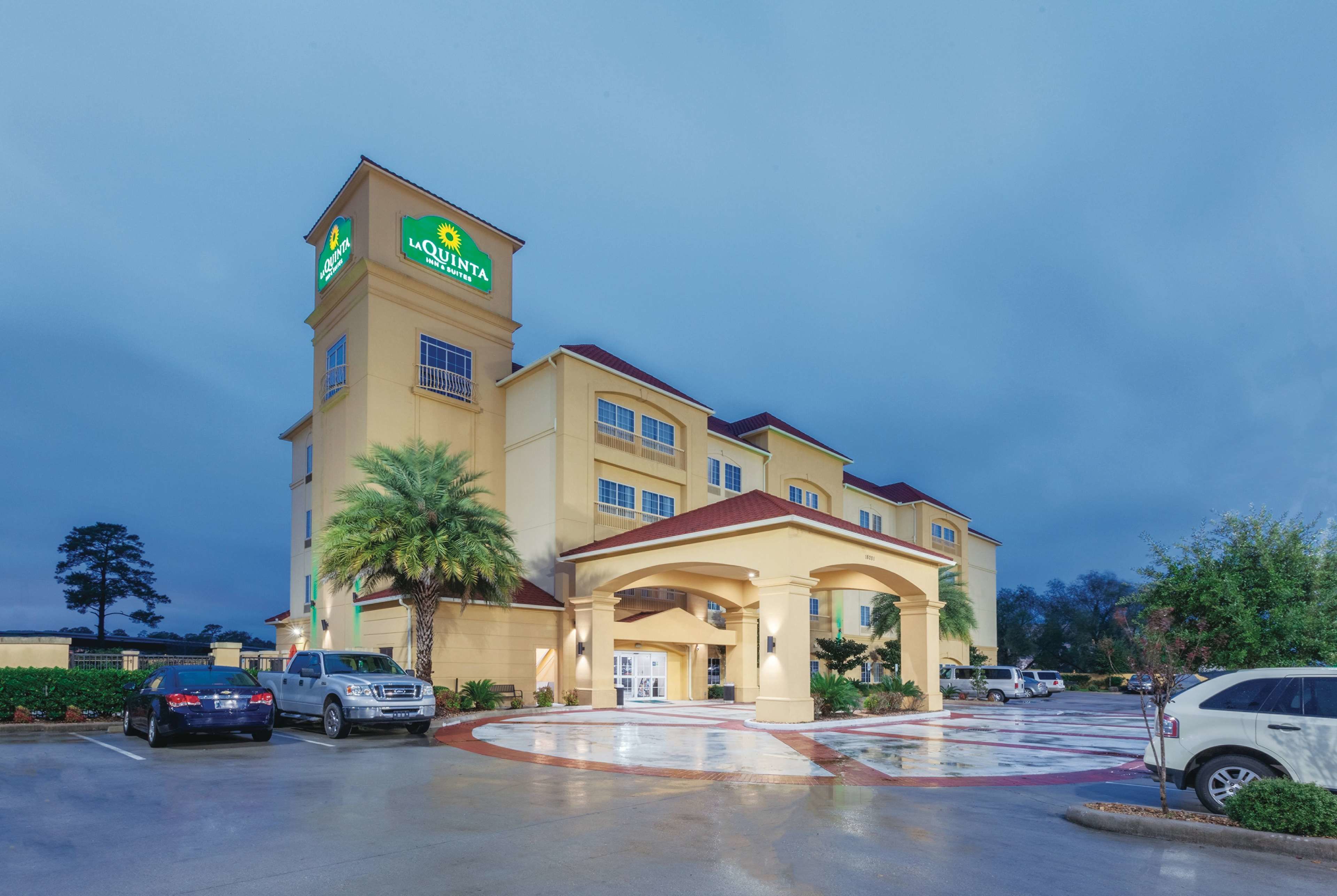 A hotel with a prominent sign, a covered entrance, and a parking lot.