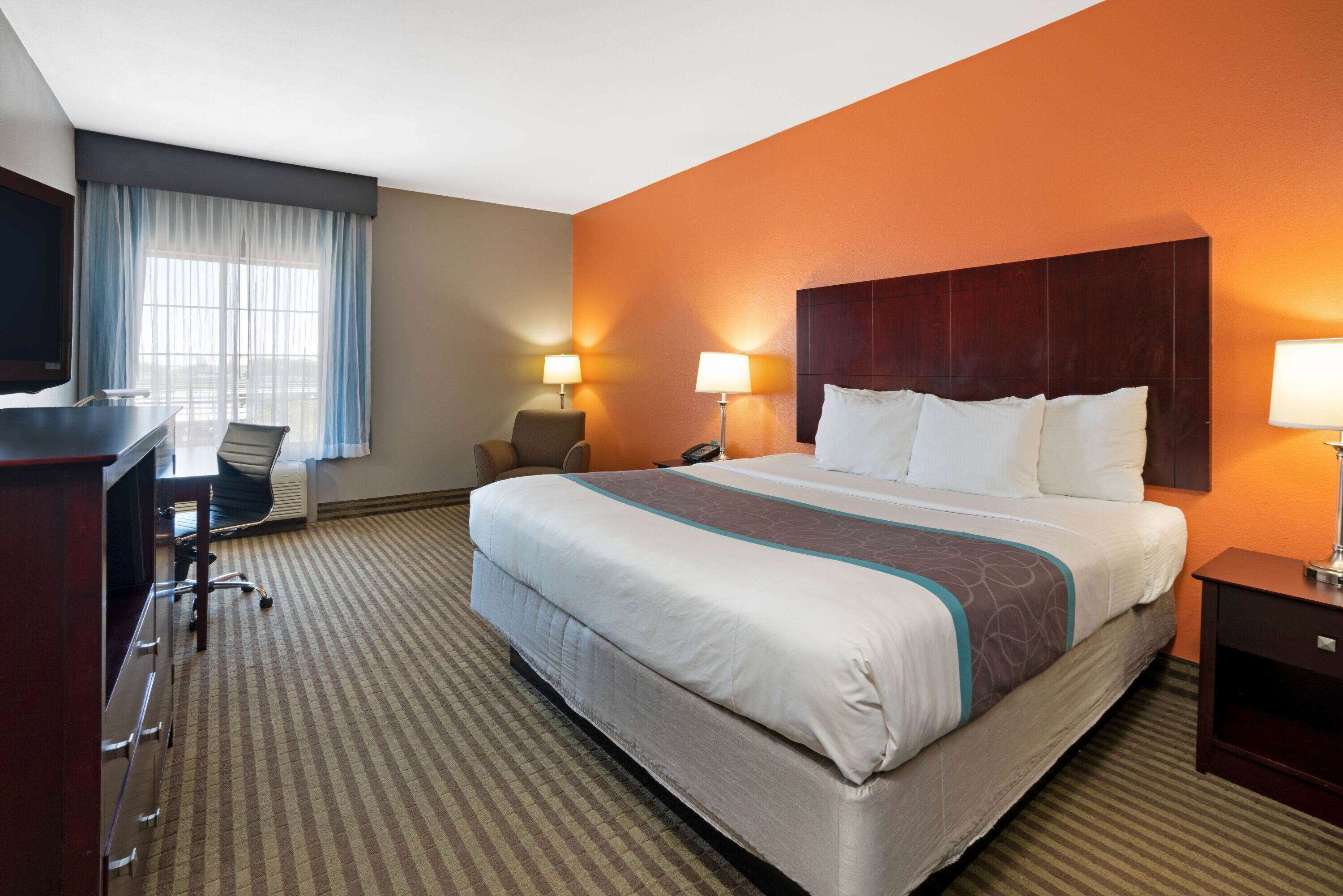 Een hotelkamer met een groot bed, een bureau, een stoel en een televisie.