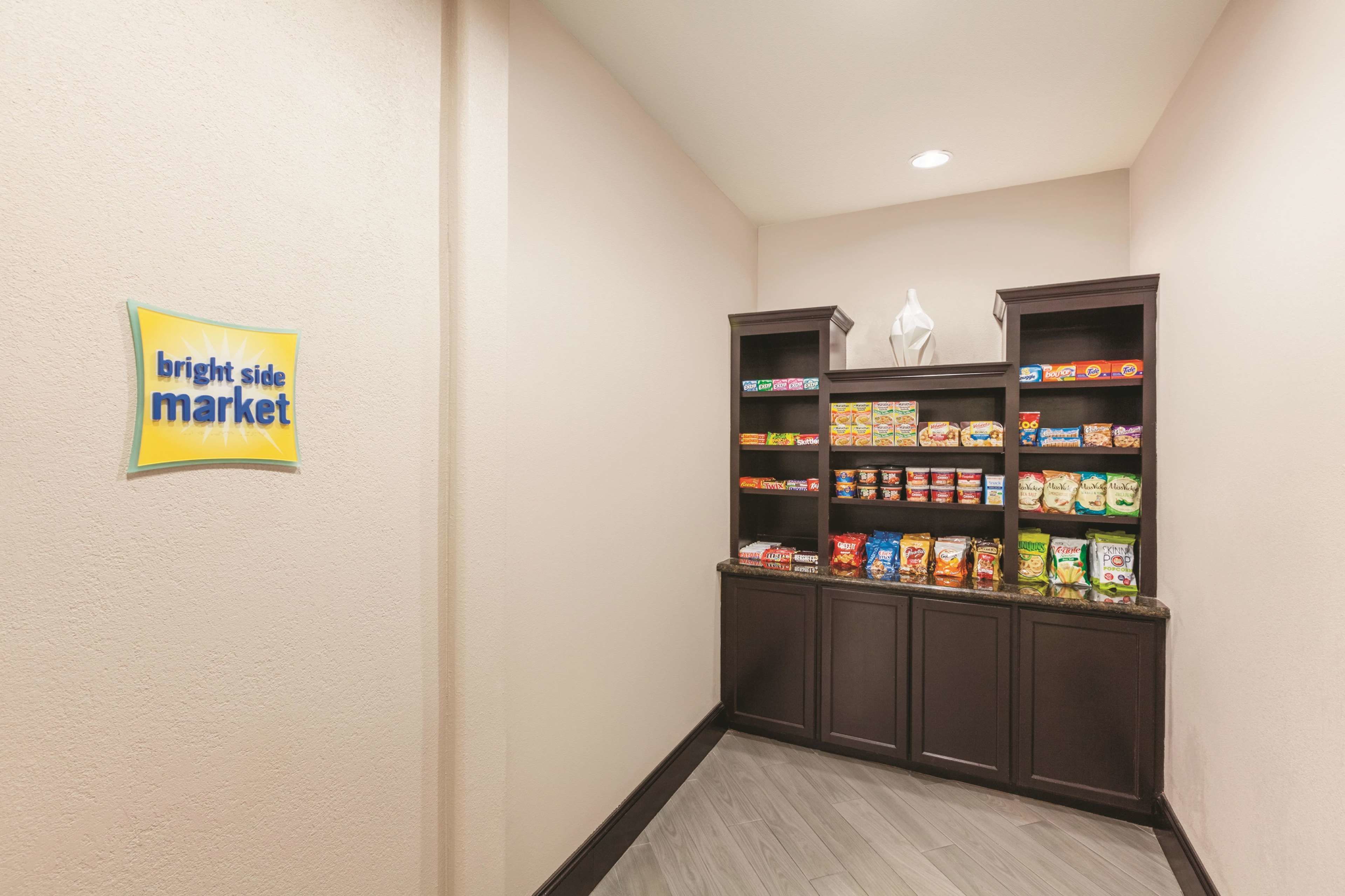 Un couloir avec une enseigne indiquant « Bright Side Market » et des étagères remplies de collations et de boissons.